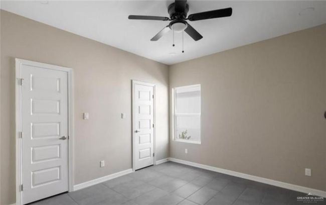 Unfurnished bedroom featuring tile patterned floors and ceiling fan | Image 7