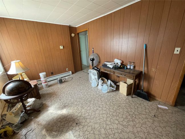 Office area featuring wooden walls and baseboard heating | Image 13