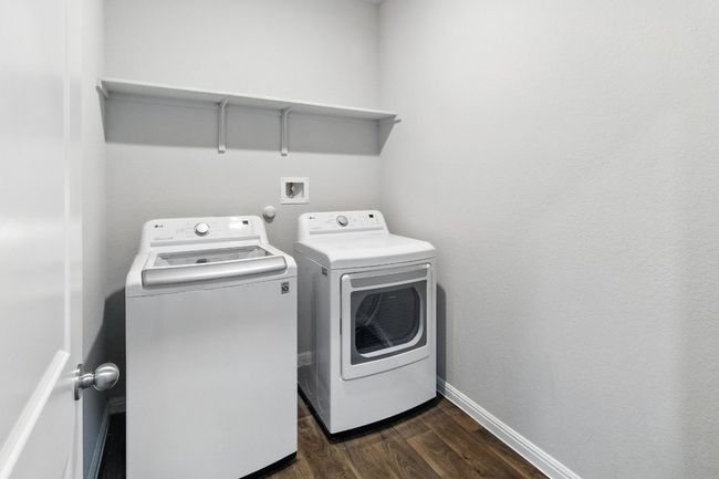 Laundry room featuring washing machine and dryer and dark wood-type flooring | Image 21