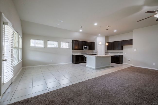 Kitchen with stainless steel microwave, open floor plan, light tile patterned floors, light countertops, and recessed lighting | Image 16