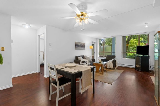 Dining area featuring baseboard heating, wood finished floors, a ceiling fan, and baseboards | Image 4