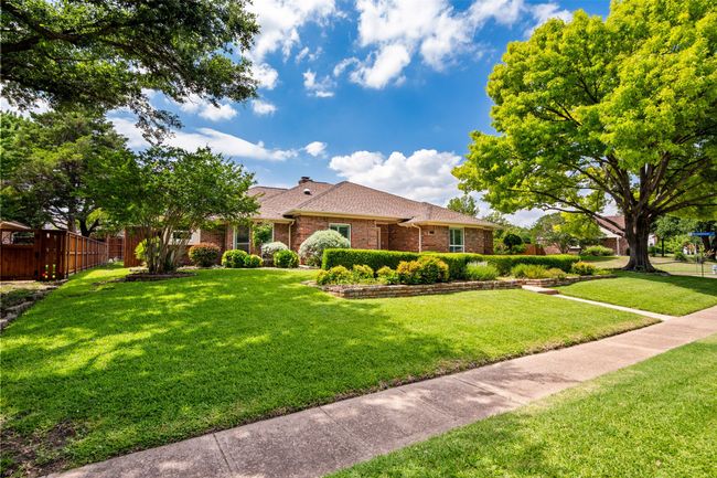 Single story home with brick siding, a chimney, and a shingled roof | Image 36