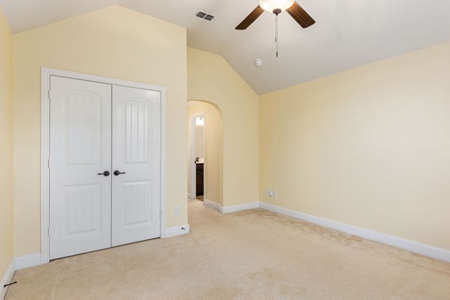 Unfurnished bedroom with vaulted ceiling, visible vents, light carpet, arched walkways, and a closet | Image 34