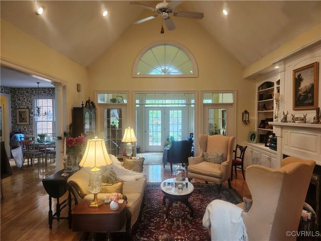 Living area with recessed lighting, wood finished floors, a ceiling fan, french doors, and high vaulted ceiling | Image 4