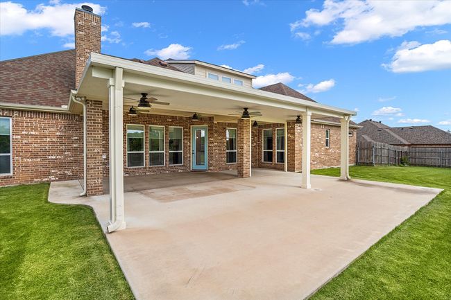Back of house with ceiling fan, a chimney, brick siding, a patio, and a shingled roof | Image 34