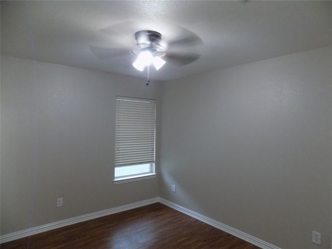 Spare room with dark wood-style flooring and a ceiling fan | Image 26