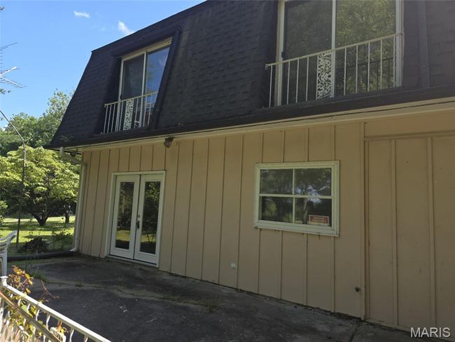 View of side of home with a balcony, mansard roof, a shingled roof, french doors, and a patio | Image 10