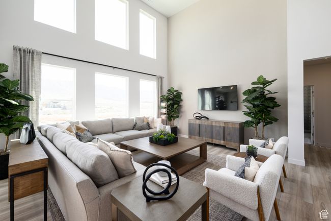 Living room with a towering ceiling, light wood-type flooring, and baseboards | Image 8