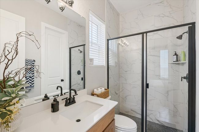Full bathroom featuring vanity, toilet, and a marble finish shower | Image 7
