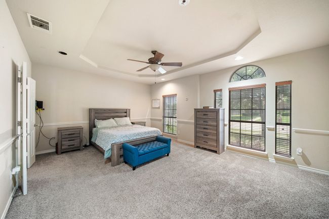 Carpeted bedroom with baseboards, visible vents, recessed lighting, and a raised ceiling | Image 18