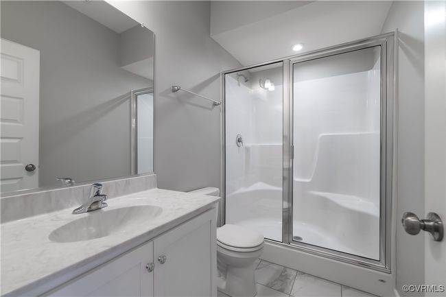 Bathroom featuring toilet, a shower with door, tile floors, and oversized vanity | Image 17