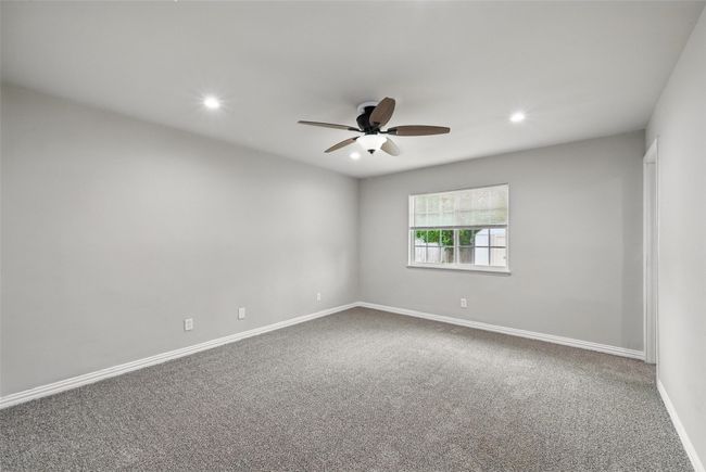 Carpeted empty room with a ceiling fan, baseboards, and recessed lighting | Image 9