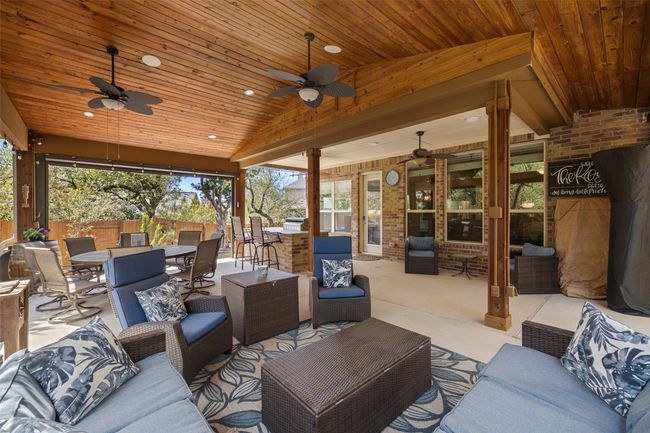 Designed for year round enjoyment, featuring a spacious 500 sq ft covered patio with wood plank ceiling, multiple fans, west facing built-in shade, built-in kitchen, gas grill, sink, and fridge, and wired sound & WiFi | Image 23