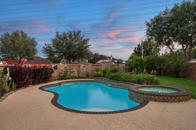 Meet me by the pool! Casual poolside living can be yours to enjoy in this beautiful landscaped backyard, pool, adjoining patio and garden areas. | Image 4