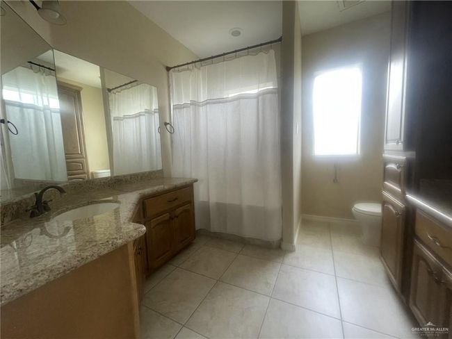 Full bath featuring vanity, tile patterned flooring, and curtained shower | Image 9
