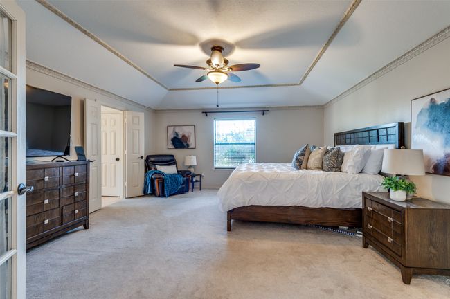 Carpeted bedroom with lofted ceiling, ceiling fan, ornamental molding, and a raised ceiling | Image 22