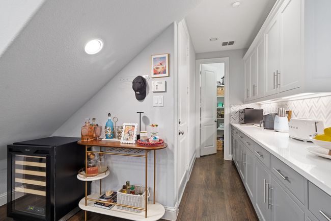 Bar featuring decorative backsplash, beverage cooler, dark wood-style flooring, and recessed lighting | Image 10