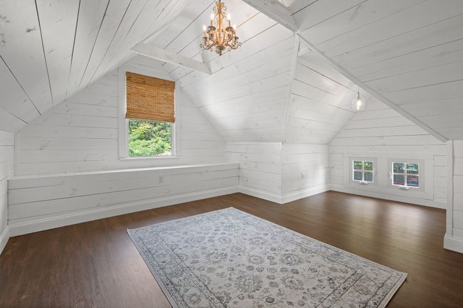 Upstairs bedroom featuring a chandelier, dark wood-type flooring, vaulted ceiling, wood walls, and wooden ceiling | Image 19