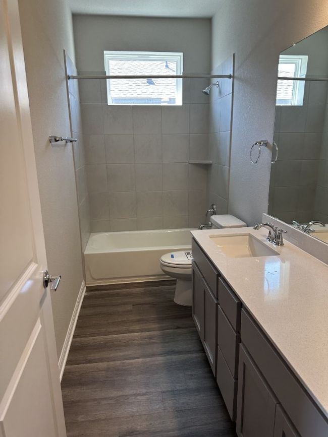 Full bath with toilet, vanity, wood finished floors, baseboards, and tub / shower combination | Image 7