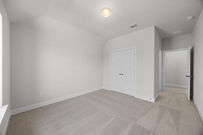 Unfurnished bedroom featuring a closet, light carpet, lofted ceiling, and baseboards | Image 25