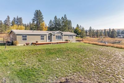 View of front facade featuring a front lawn and a wooden deck | Image 1