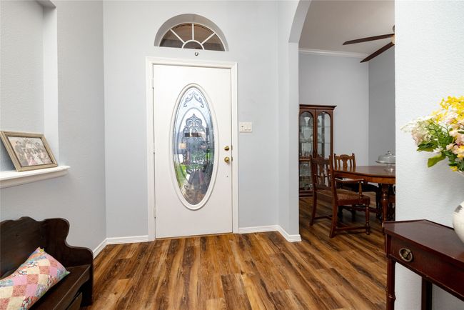 Entrance foyer with wood finished floors, ornamental molding, arched walkways, baseboards, and ceiling fan | Image 5