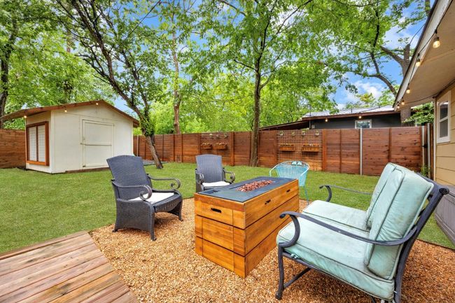 Deck featuring a fenced backyard, a shed, and a fire pit | Image 23