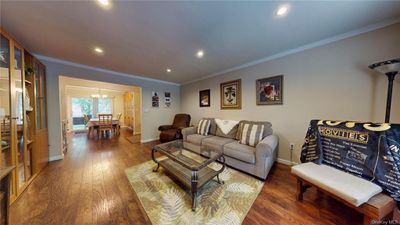 Living room with an inviting chandelier, dark hardwood / wood-style flooring, and crown molding | Image 2