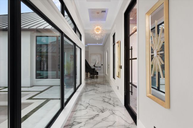 Hallway featuring marble finish floor and a chandelier | Image 4