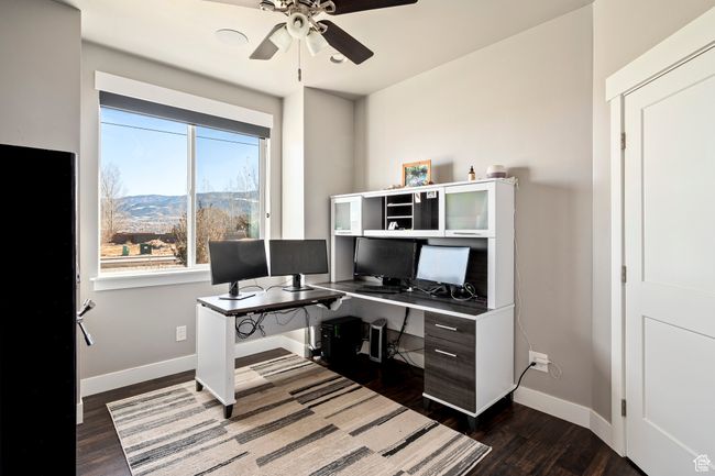 Office space with dark wood-type flooring, ceiling fan, and baseboards | Image 28