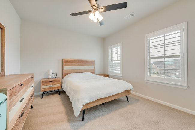 Bedroom featuring baseboards, visible vents, ceiling fan, and light colored carpet | Image 25