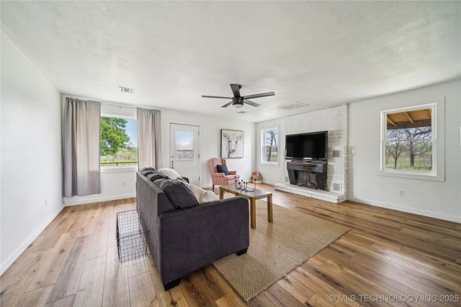Living room featuring hardwood / wood-style floors, a ceiling fan, and baseboards | Image 15