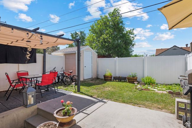 Fenced backyard featuring a patio, a storage unit, and outdoor dining space | Image 21