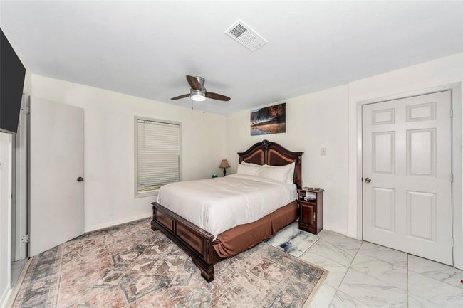Bedroom featuring a ceiling fan and light marble finish flooring | Image 18