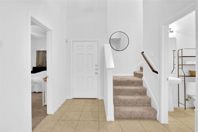Foyer with light carpet, light tile patterned floors, and baseboards | Image 4