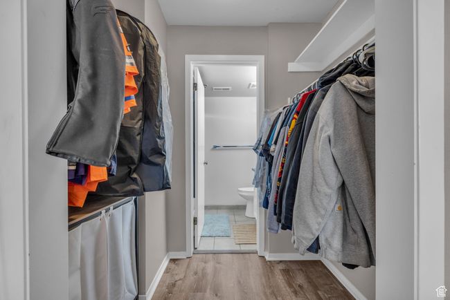 Walk in closet with visible vents and wood finished floors | Image 10
