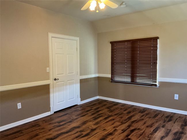 Unfurnished room featuring dark wood-type flooring, vaulted ceiling, a ceiling fan, and baseboards | Image 15
