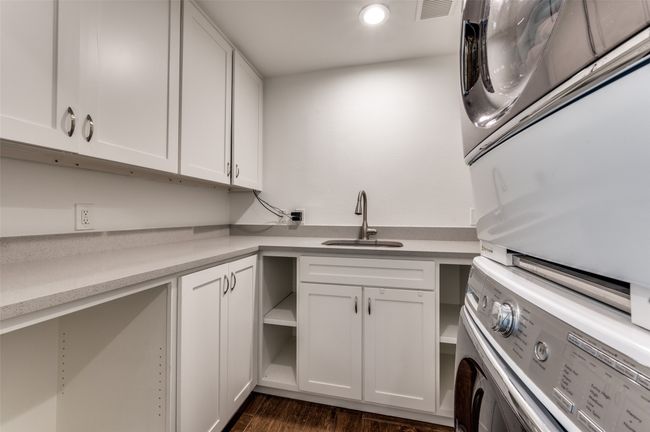 Washroom with estacked washer and dryer, cabinet space, dark wood finished floors, and recessed lighting | Image 28