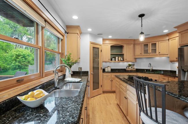 Beautifully functional — this kitchen stuns with sleek black granite countertops and timeless design. | Image 11