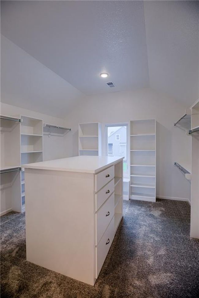 Walk in closet with lofted ceiling and dark colored carpet | Image 35