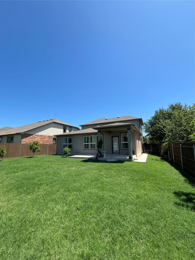 Rear view of house featuring a fenced backyard, a patio, and a yard | Image 27