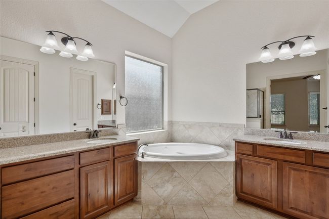 Bathroom with two vanities, a bath, a shower stall, and vaulted ceiling | Image 30