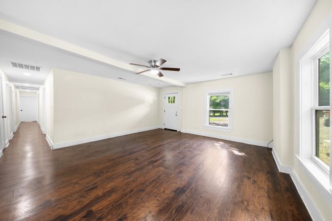 Spare room featuring healthy amount of natural light, dark wood-style floors, and a ceiling fan | Image 6