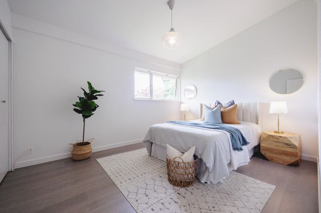 Bedroom with wood finished floors and lofted ceiling | Image 17
