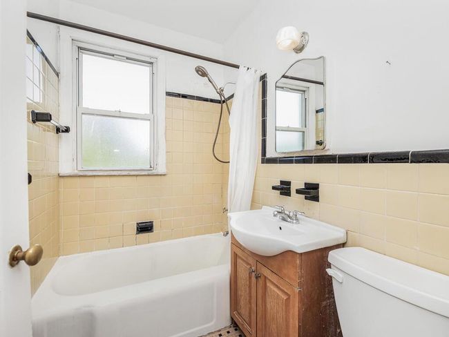 Full bathroom with vanity, toilet, shower / tub combo with curtain, and tile walls | Image 9