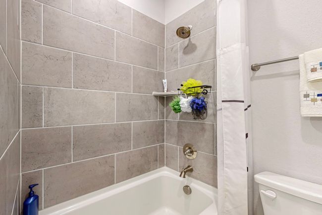 Bathroom with toilet and shower / bathtub combination with curtain | Image 24