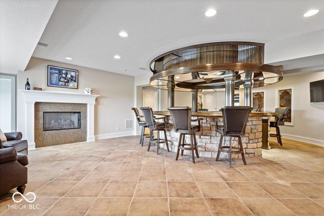 The basement bar area features this homes 3rd gas fireplace. | Image 29