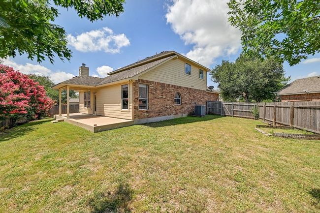 Back of house featuring brick siding, a patio area, a fenced backyard, and a chimney | Image 25