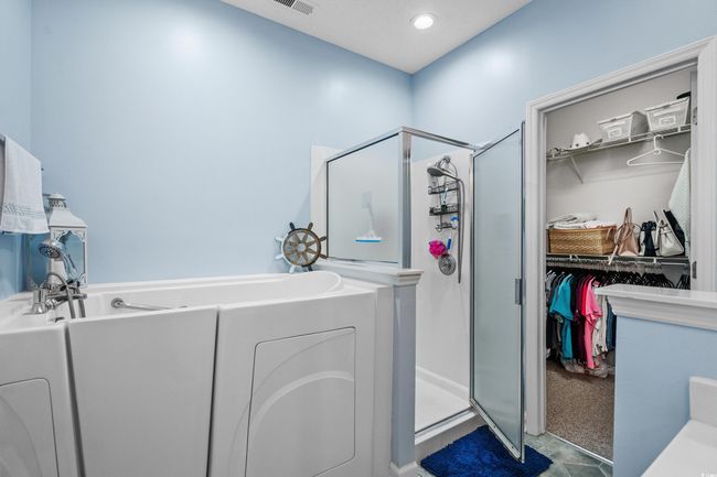 Bathroom featuring a stall shower, a spacious closet, and a garden tub | Image 25