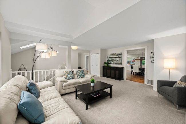 Living room featuring carpet, visible vents, and vaulted ceiling | Image 9